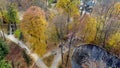 Park, trees yellow falling leaves, architecture, lake, people walking dirt paths