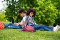 Two curly-haired teens sitting on the grass in the park and feeling good Royalty Free Stock Photo