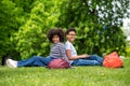 Two curly-haired teens sitting on the grass in the park and feeling good Royalty Free Stock Photo