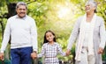 Park, walk and grandparents holding hands with child, smile and bonding on outdoor adventure together. Old man, woman Royalty Free Stock Photo