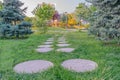 Park walkway with separated, round and flat concrete blocks in the grass