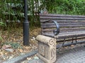 Park wooden bench on carved stone base