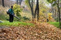 A park worker removes fallen leaves in one of the parks in downtown of Kyiv, Ukraine. October 2019