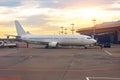 Parked aircraft on an airport through the gate window, evening light sunset dawn