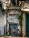 Parked bicycle on sidewalk in front of folding steel door next to door of old house