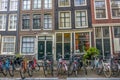 Parked Bicycles in Front of the Facades of a Townhouses in Amsterdam Royalty Free Stock Photo