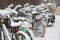 Parked bikes covered in snow with depth of field in an alleyway in Dordrecht in The Netherlands. Typical dutch wintertime urban Royalty Free Stock Photo