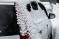 a parked car covered with snow taillight on the trunk lid with a clean rear window and snow-covered side windows. Royalty Free Stock Photo