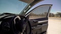 Parked car on a dirt road. Salon from the inside, dashboard, steering, open door