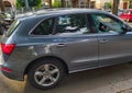 A parked car has been broken into: the front right window is reduced to tiny splinters, some are on the pavement, others scattered Royalty Free Stock Photo