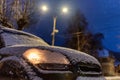 Parked car with light on covered by snow at night Royalty Free Stock Photo