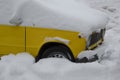 Parked yellow car under snow cover. Winter parking background Royalty Free Stock Photo