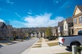 Parked cars at front garage along residential street leading down a steep hill in new development suburban neighborhood suburbs