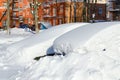 Parked cars under snowdrifts in city yard after snowfall in March Royalty Free Stock Photo