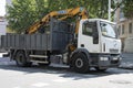 Crane truck on city streets. It is a white Iveco Eurocargo.