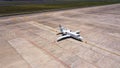 Parked expensive private airplane on concrete ground of airport, aerial. Small business jet parked on the runaway Royalty Free Stock Photo