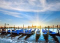 Parked gondolas on Piazza San Marco and The Doge Palace embankment and sunset sunshine Venice, Italy
