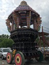 Parked Hindu procession chariot amongst devotees cars