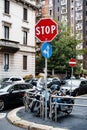 Parked motorcycles on the street corner near the STOP sign. Milan, Italy