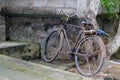 Parked old bicycle near stone wall in Asia. Royalty Free Stock Photo