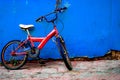 Parked red bike  on blue wall Royalty Free Stock Photo