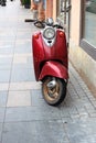 Red moped parked near the building wall Royalty Free Stock Photo
