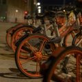 Parked rentable bikes in downtown Berlin, Germany. The bikes are standing in the light of a lantern at evening