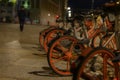 Parked rentable bikes in downtown Berlin, Germany. The bikes are standing in the light of a lantern at evening