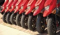 parked rental moped in row, lower view. parked rental moped red color. parked rental moped