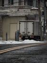 Parked rusty truck on the sidewalk covered with snow in winter