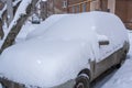 Parked snow-covered cars near houses in the courtyard in winter Royalty Free Stock Photo