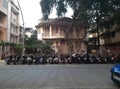 Parked vehicles in front of old art deco style building in Mumbai