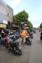 a parking attendant helping to remove a motorbike from a shop visitor