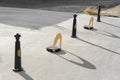 Parking barriers with No Stopping road sign and poles on asphalt outdoors