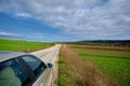 Parking of a car on gravel road and magnificent green grass near the road Royalty Free Stock Photo