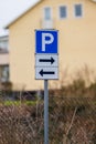 parking direction sign with urban background.. Royalty Free Stock Photo