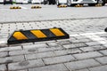 Parking limiters with yellow stripes on parking lot outdoor.