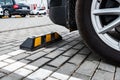Parking limiters with yellow stripes on parking lot outdoor.