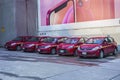 Parking lot with five red cars.