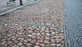 Parking lot of irregular rough red stones divided by gray granite stones. connects to the square with benches and a pedestrian zon Royalty Free Stock Photo