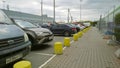 Parking lot with many cars of buyers near supermarket - one of largest players of retail industry. Yellow road barriers. Shopping