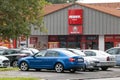 A parking lot with many colourful cars with blue Skoda Octavia in front of the shop of the Penny Market supermarket chain in Czech