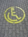 Parking place for disabled, yellow sign on grey brick Royalty Free Stock Photo