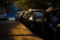 Parking. A row of cars in a parking lot lit by yellow sunlight in a dark, shady courtyard.