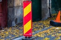 Parking spot with orange safety cones standing and autumn leaves in Bucharest, Romania, 2019