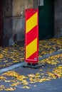 Parking spot with orange safety cones standing and autumn leaves in Bucharest, Romania, 2019