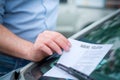 Parking ticket violation notice placed under windshield wiper Royalty Free Stock Photo