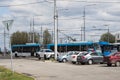 Parking trolleybuses and cars among street lights on a sunny spring day