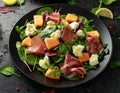 Parma ham and melon salad with mozzarella, green leaves mix Royalty Free Stock Photo