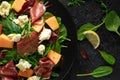 Parma ham and melon salad with mozzarella, green leaves mix Royalty Free Stock Photo